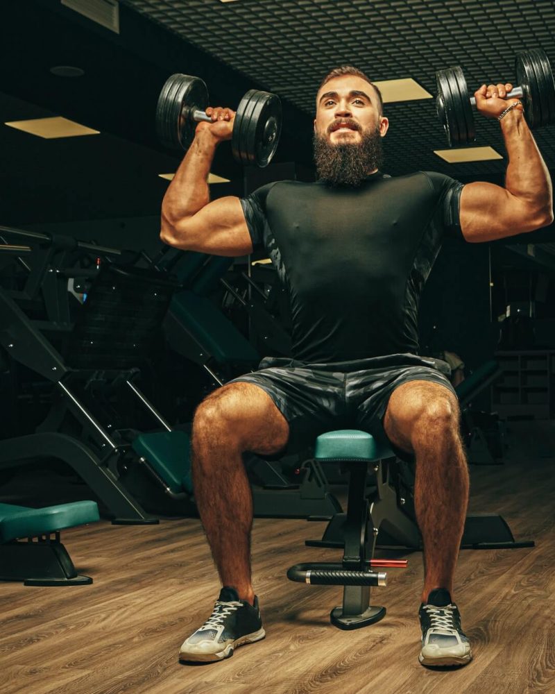 muscular-young-man-lifting-weights-in-a-dark-gym-1.jpg